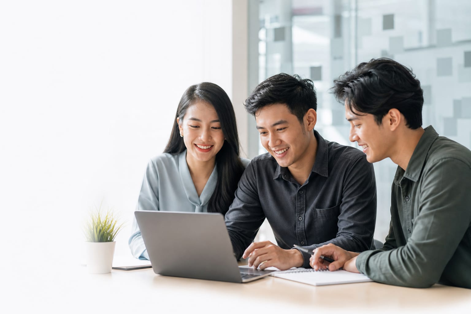 A young Indonesian professional team collaborating in a welcoming technology office